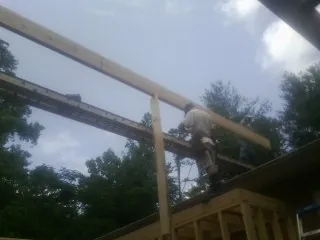 Carpenter setting a ridge beam over a new addition frame — Ice Dam Removal by Roofing Brothers in Forest Knolls