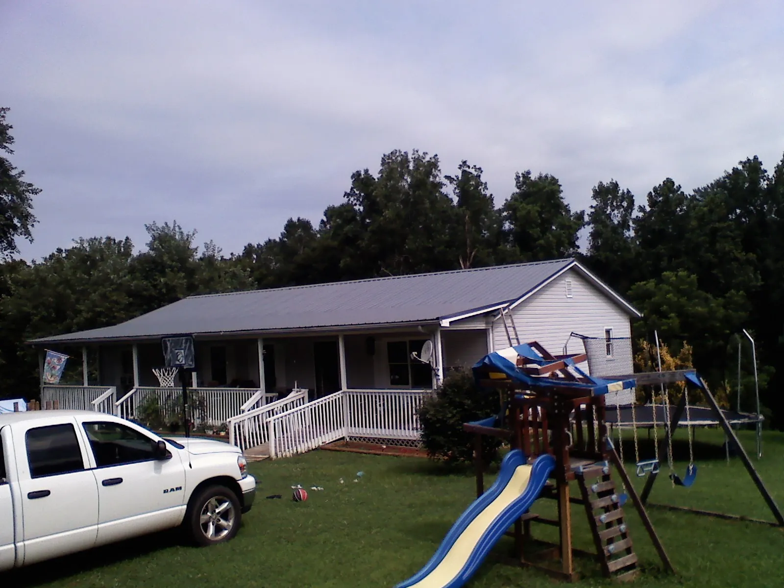 Dark metal roof on a country home with a full length front porch in Forest Knolls